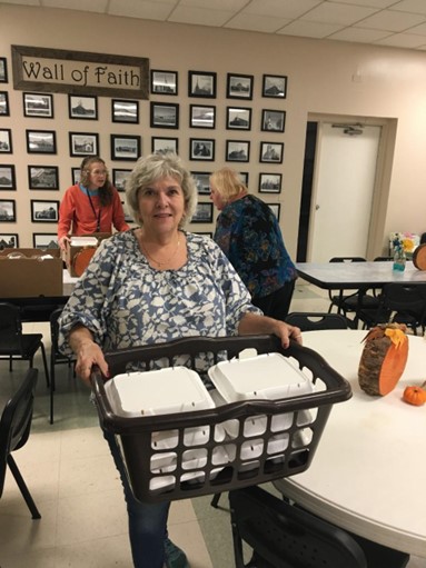 Patti holding food donation items
